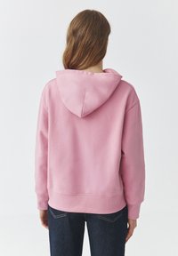 Felpa rosa in cotone con cappuccio regolabile, maniche lunghe e polsini e bordo a coste. Tessuto morbido e design semplice, privo di decorazioni.