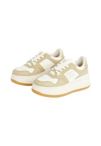 Sneakers beige e bianchi con suola spessa, caratterizzati da una tomaia testurizzata, perforazioni sulla punta e un branding sottile di lato.