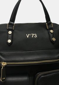 Zwarte handtas van glad nylon en leer, met gouden hardware, merklogo (V°73) en ritscompartimenten.