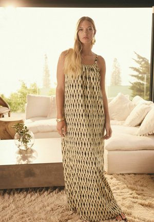 Maxi sukienka z lekkiego, wzorzystego materiału z motywem ikat w czerni i kremie. Na cienkich ramiączkach, o luźnym kroju.