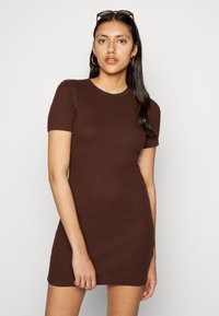 Vestido castanho de manga curta com um design ajustado e textura ribada. Decote redondo e comprimento acima do joelho. Simples e de cor sólida.