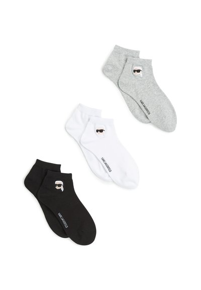 Trois paires de chaussettes de cheville : noires, blanches et grises. Chacune présente un petit visage de dessin animé avec des lunettes de soleil et un logo. Matériau en mélange de coton.