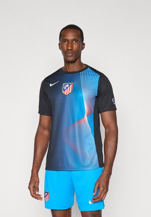 Nike sports jersey i sort og blå, med et klublogo, geometrisk mønster og korte ærmer, parret med lyseblå shorts.
