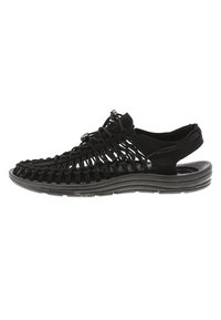 Black sandal with woven upper design, rubber sole, adjustable bungee closure, and open heel for breathability. Lightweight and textured.