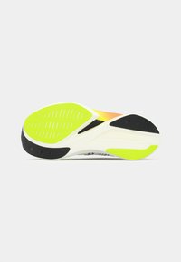 Semelle de chaussure de course avec une base blanche, des accents noirs et des détails jaunes vifs, dotée d'un motif de grip texturé. Dégradé d'orange à jaune.