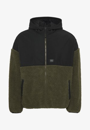 Veste à capuche avec le haut noir et le bas en polaire vert olive. Fermeture éclair, deux poches latérales et une étiquette de marque sur la poitrine.