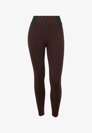 Leggings marron taille haute avec une fermeture éclair devant et des panneaux latéraux élastiques noirs, silhouette ajustée, longueur cheville.