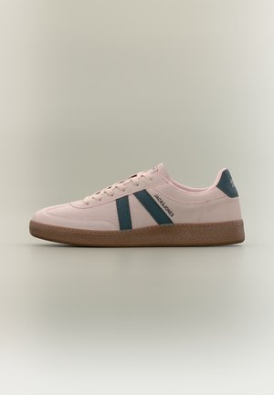Zapatilla deportiva informal de color rosa claro con suela marrón, rayas laterales azules, marca "JACK & JONES" y parche azul en el talón sobre fondo neutro.