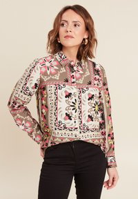 Blusa a maniche lunghe con stampa floreale e geometrica multicolore, dotata di colletto con bottoni, polsini a contrasto e vestibilità comoda.