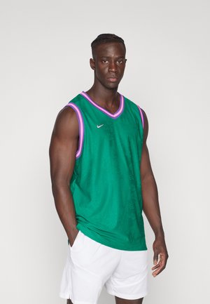 Jersey sin mangas verde con acentos rosa, que presenta un diseño de cuello en V y una superficie texturizada. El logo de Nike está presente en el pecho.