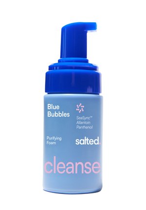 Bottiglia blu con dispensatore blu scuro etichettata "Blue Bubbles" schiuma purificante di Salted, contenente SeaSync, Allantoina e Pantenolo.