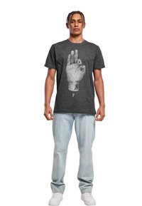 Grå t-skjorte med korte ermer som viser et detaljert grafisk motiv av en hånd med tatoveringer, vist på en mannlig modell i kombinasjon med lys blå jeans.