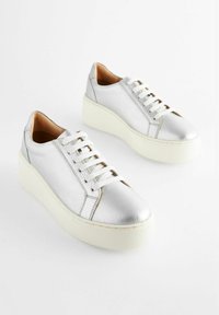 Silver leather sneakers with a textured finish, lace-up design, and white rubber platform sole. Smooth and textured accents present.
