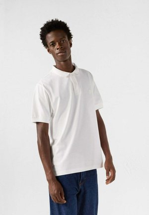 Witte poloshirt van katoen, met een klassieke kraag en korte mouwen. Het shirt heeft een subtiele ronde logo op de borst en een ontspannen pasvorm.
