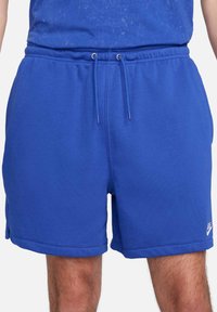 Shorts blu in cotone con cintura elastica, lacci, tasche laterali e logo Nike sulla parte inferiore della gamba destra.