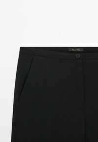 Mustat housut, joissa on sileä pinta, edessä nappikiinnitys, vyölenkit ja sivutaskut. Minimalistinen muotoilu, ilman kuvioita tai korostuksia.