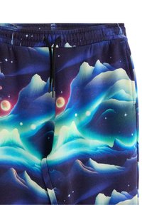 Spodnie dresowe z polaru z kosmicznym nadrukiem gór w odcieniach niebieskiego, fioletowego i białego, z elastycznym pasem i czarnym sznurkiem.