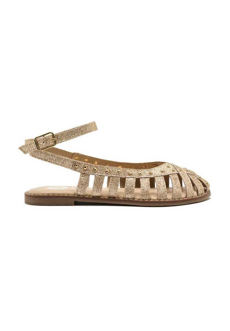 Sandalias slingback de purpurina dorada con diseño de punta abierta, que presentan múltiples recortes y tachuelas redondas a lo largo de la correa. Suela plana.
