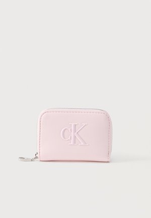 Portofel mic, roz pal, cu fermoar, având logo "cK" în relief și capăt de fermoar argintiu, așezat pe un fundal simplu, deschis la culoare.