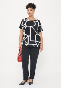 Black and white patterned short-sleeve top paired with black pants, red handbag, and black polka-dot heels. Flat texture, casual design.