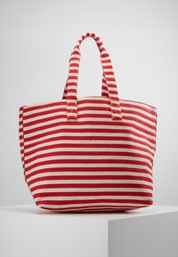 Sac fourre-tout en tissu rayé rouge et blanc avec double anses, de forme rectangulaire, en matériau robuste et avec des rayures horizontales proéminentes.