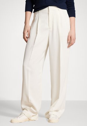 Cream wide-leg trousers made of smooth fabric, featuring front pleats and a high waist. Paired with white sneakers.
