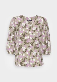 Blusa floral com decote em V, mangas curtas bufantes e fecho de botão. Apresenta um fundo bege com flores roxas e brancas. Tecido leve.