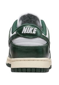 Sneaker Nike Dunk con tomaia in pelle verde, dettagli bianchi, logo in rilievo sul tallone e suola in gomma beige con scanalature.