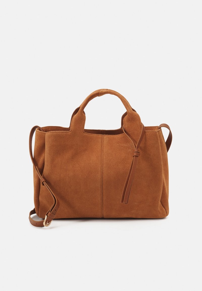Sac à main en daim brun avec poignées courtes, bandoulière réglable et texture douce. Comprend une couture centrale et un détail de lien en cuir.