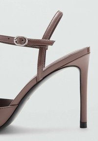 Sandal alta con tacco, marrone, con finitura lucida, sottile cinturino alla caviglia, dettaglio della fibbia argento e design elegante con punta affusolata.