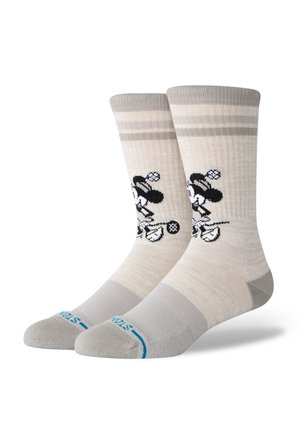 Knee-high socks in beige with gray stripes. Features a black cartoon character design. Smooth texture and reinforced toe areas.