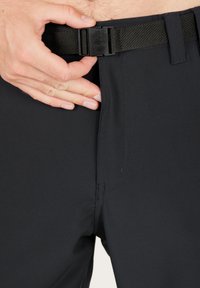 Svarta shorts med en mjuk textur, elastisk midjeband och en säker plastspänne. Designen inkluderar diskreta sömnadsdetaljer.