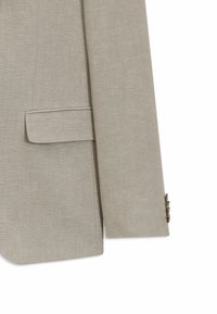 Manga de chaqueta de traje de lino beige y solapa del bolsillo lateral, con cuatro botones en el puño, sobre un fondo blanco.