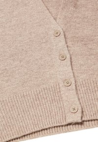 Cardigan beige chiaro con scollo a V, dotato di un orlo a costine e cinque bottoni in tinta. Tessuto morbido e strutturato con una finitura liscia.