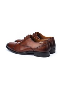 Scarpe eleganti in pelle marrone con finitura liscia, punta tonda, design con lacci e suole in gomma nera, con dettagli di cucitura discreti.