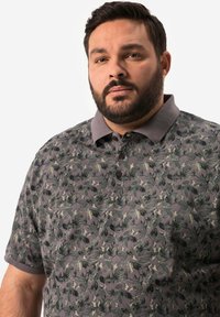 Korte ærmer polo skjorte i mørkegrå med et bladmønster i grønne nuancer. Har krave og tre-knaps lukning. Struktureret stof.