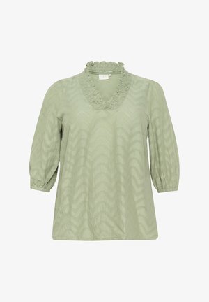 Hele roheline pluus, millel on rüütelkrae, kolmveerandi puhv-suvevarrukad ja tekstuuriga siksakmuster kogu kangas.