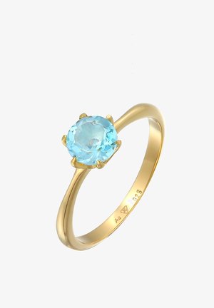 Bague en or avec une pierre précieuse ronde bleu clair maintenue par quatre griffes, gravée à l'intérieur de "Ag 925" et d'un poinçon de fabricant.