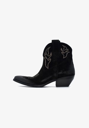 Stivali da cowboy in suede nero con punta appuntita, cuciture decorative e tacco rialzato. Presenta un design impresso sul gambale e accenti laterali.