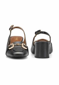 Czarne skórzane buty na obcasie typu slingback z kwadratowym noskiem, złotymi akcentami oraz grubym obcasem. Gładka tekstura i regulowany pasek wokół kostki.