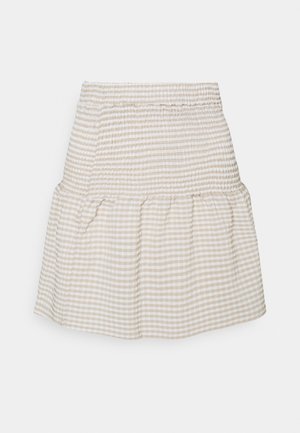 Vaaleanbeige gingham-hame, jossa on smockattu vyötárä ja röyhelöinen helma. Kangas esittää ruutukuosia pehmeissä kontrastiväreissä.