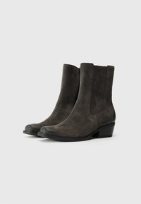 Stivaletti alla caviglia in suede grigio scuro con tacco a blocco basso, dotati di pannelli laterali elastici e punta arrotondata. Texture liscia con dettagli minimi.