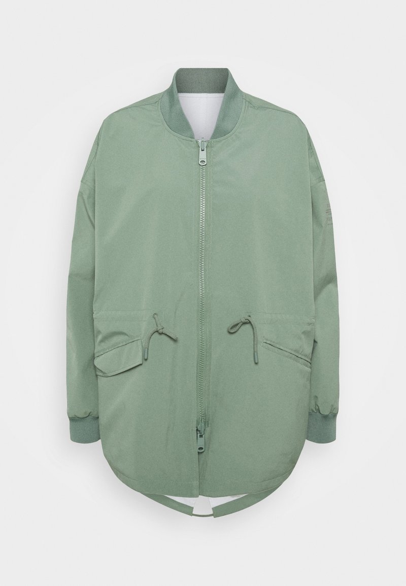 Jasnozielona kurtka bomberka z zamkiem z przodu, dwiema kieszeniami z klapami i sznurkiem, ściągaczem przy kołnierzu i mankietach oraz zaokrąglonym dołem.
