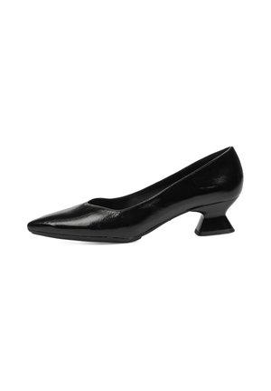 Zapato de charol negro con punta afilada, tacón geométrico curvado, textura suave y un diseño elegante.