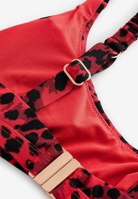 Crvena badić gornji deo sa crnim leopard printom, sa podesivim naramenicama, zlatnim detaljima, glatkom tkaninom i bešavnim ivicama.