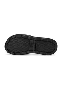 Suola di scarpa in gomma nera con un motivo a spina di pesce, design piatto e logo del marchio ben visibile al centro. Resistente con grip testurizzato.