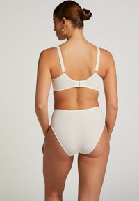 Krämfärgad bh och högmidjade trosor, med mjukt tyg, en volangkant på bh-bandet och traditionell hyska och ögla-stängning.