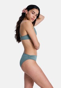 Ensemble bikini bleu clair avec un design simple, comprenant un haut dos nageur et un bas à coupe classique. Fabriqué en tissu lisse avec une finition mate.