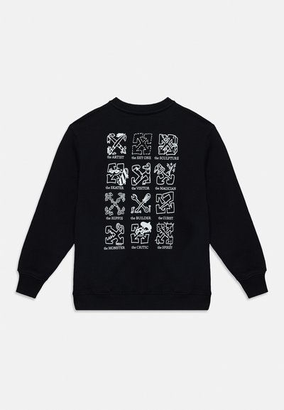 Sweat-shirt noir avec douze motifs abstraits blancs étiquetés avec des noms comme l'Artiste, le Skateur, le Constructeur et le Critique disposés en grille.