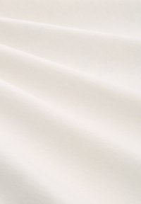 Tejido blanco suave con ondas sutiles y una textura lisa, mostrando detalles de una fina trama.